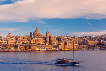 Valletta Skyline with ship at beautiful sunset from Sliema with churches of Our Lady of Mount...