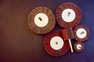 Flap Wheel. A pile of color abrasive Flap Wheel industrial on wood background texture. sandpaper wheel tool - professional equipment - obrazy, fototapety, plakaty