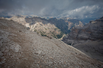Panorama of Travenanzes Valley with trekkers going up towards 3244 meters of Tofana summit, Dolomites, Cortina d'Ampezzo, Italy