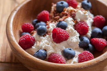 Ricotta Cottage cheese for breakfast with granola, honey and berries raspberries blueberries