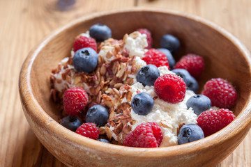 Ricotta Cottage cheese for breakfast with granola, honey and berries raspberries blueberries