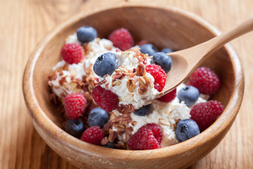 Ricotta Cottage cheese for breakfast with granola, honey and berries raspberries blueberries