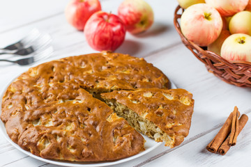 Homemade apple pie with cinnamon and fresh ripe apples in the background