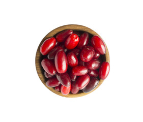 Cornels isolated on a white background. Cornels in a bowl with copy space for text. Ripe cornel close-up. Background berry. Top view