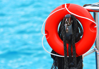 Red lifebuoy at the rescue station on the background of the sea