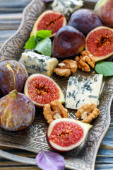 Fresh figs with blue cheese on a bronze tray.