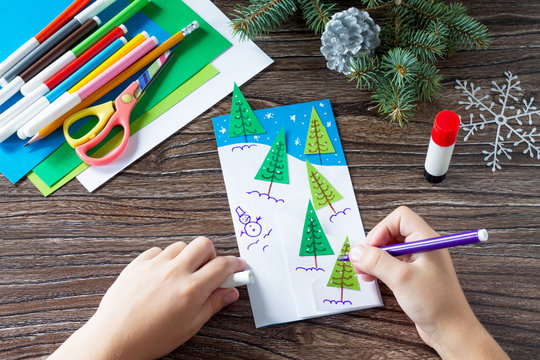 The child draws the details of the manufacture of paper cards Christmas. Made with your own hands. Children's art project crafts for kids. Crafts for a child.