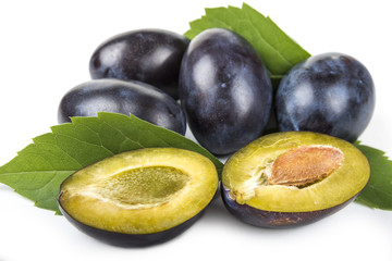 Plums in the wooden basket on the white background
