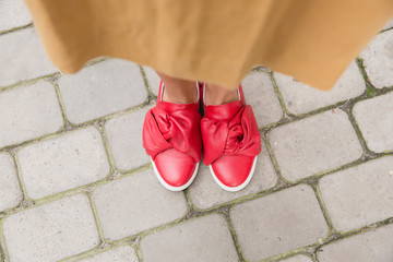 Women's feet in red leather shoes. Street fashion style