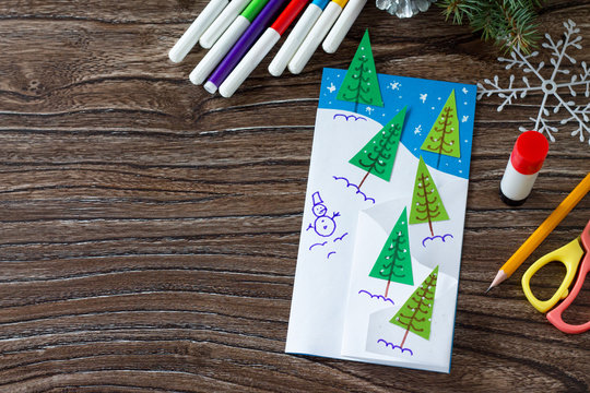 The child makes a greeting card Christmas. Made with his own hands. Children's art project craft for kids. Craft for children. Copy space for your text.