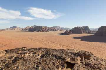 Fototapeta na wymiar Reddish sand and rock landscapes in the desert of Wadi Rum, southern Jordan