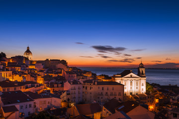 Fototapeta premium View of the Alfama neighborhood from the Portas do Sol viewpoint at sunrise in Lisbon, Portugal; Concept for travel in Portugal