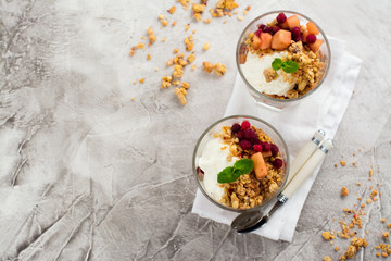 Layered dessert with granola, apple and red bilberry compote, cream
