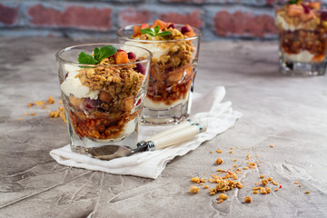 Layered dessert with granola, apple and red bilberry compote, cream