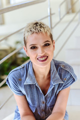 Portrait of a blonde fashion woman in jeans jacket with short stylish  hair. with professional makeup and bare shoulders. close up