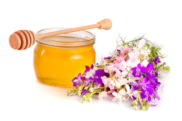 Jar of honey with wildflowers isolated on white background