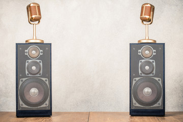 Retro stereo acoustic speakers system and golden microphones front concrete wall background. Listening music concept. Vintage old style filtered photo