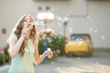 happy woman blowing soap bubbles 