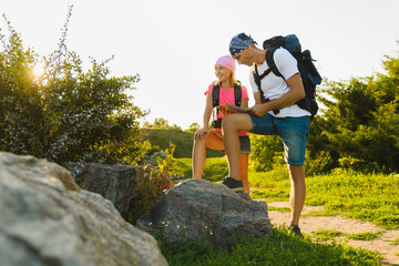Man and girl with backpack resting and looking at map