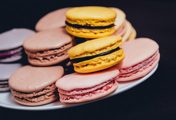 Colorful macaroons. Sweet macarons on retro dark background.