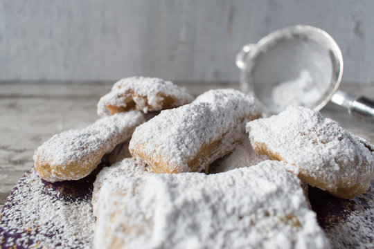 Homemade beignets with powdered sugar in rustic setting detail