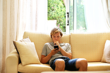 Teenage boy typing text message.Using smart phone. © lado2016