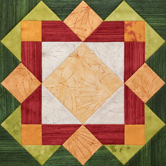 Bright orange-green geometric patchwork block from pieces of fabrics