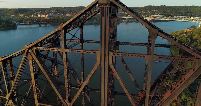 A high angle lowering aerial establishing shot of the various bridges spanning the Ohio River in Western Pennsylvania. The towns of Monaca and Rochester, PA in the distance.  	