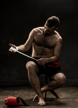 Boxer tying tape around his hand preparing to fight