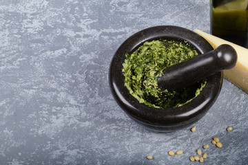 Mortar with pesto on grey stone