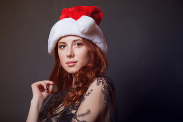 Portrait of young redhead woman in Santa Claus hat