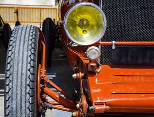 Fototapeta premium close up front left of a vintage red sports car..Detail of headlight