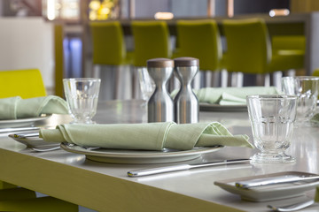 dishes and glasses with napkin on dining table