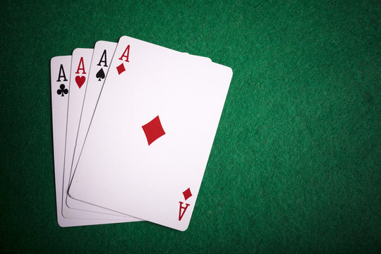 Four aces on green poker table