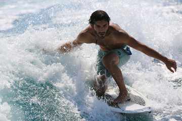 Young man surfing on the wave.