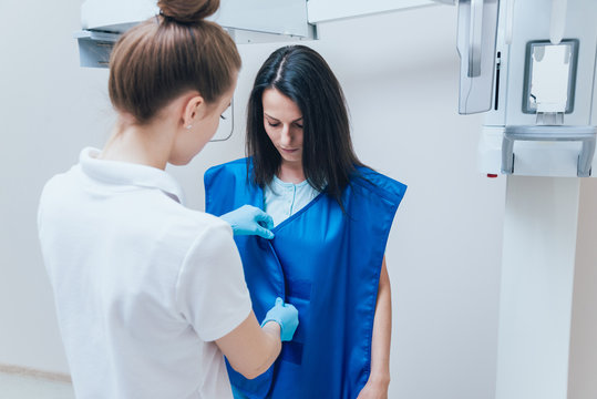 Young woman patient standing in x-ray machine.