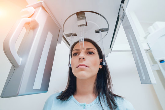 Young woman patient standing in x-ray machine.