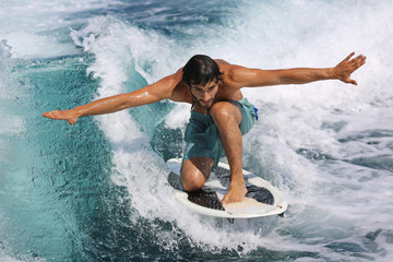 Young man surfing on the wave.