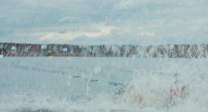 Attractive female wake boarding in a wakepark near a city. 4K UHD 60 FPS 