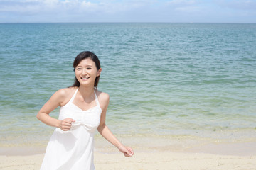 Fototapeta na wymiar 海辺で遊ぶ笑顔の女性