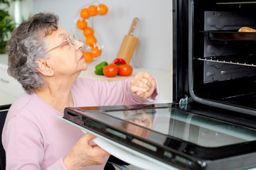 grandmother on wheelchair putting pie in oven
