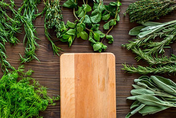 flat lay with fresh herbs and greenery for drying and making spices set on wooden kitchen background mock-up