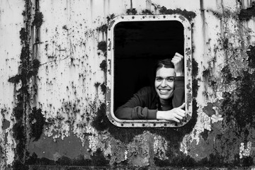 Black and white portrait of happy young woman in the window vintage train.