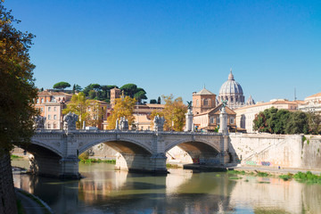 Obraz premium St. Peter's cathedral over bridge and Tiber river water in Rome, Italy