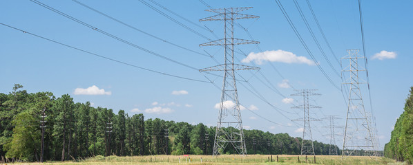 Parallel rows of transmission towers (power tower, electricity pylon, steel lattice tower) cloud...