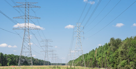 Parallel rows of transmission towers (power tower, electricity pylon, steel lattice tower) cloud...
