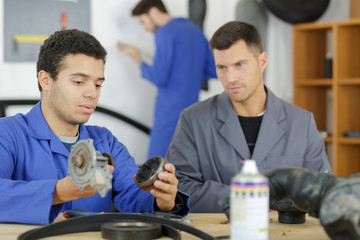 student with auto part studying automotive trade