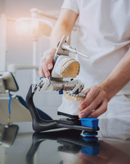 Dental technician working with articulator in dental lab