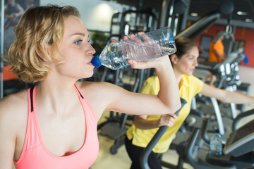 muscular woman drinking water in crossfit