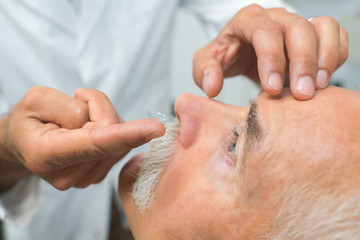 doctor putting contact lenses to patient
